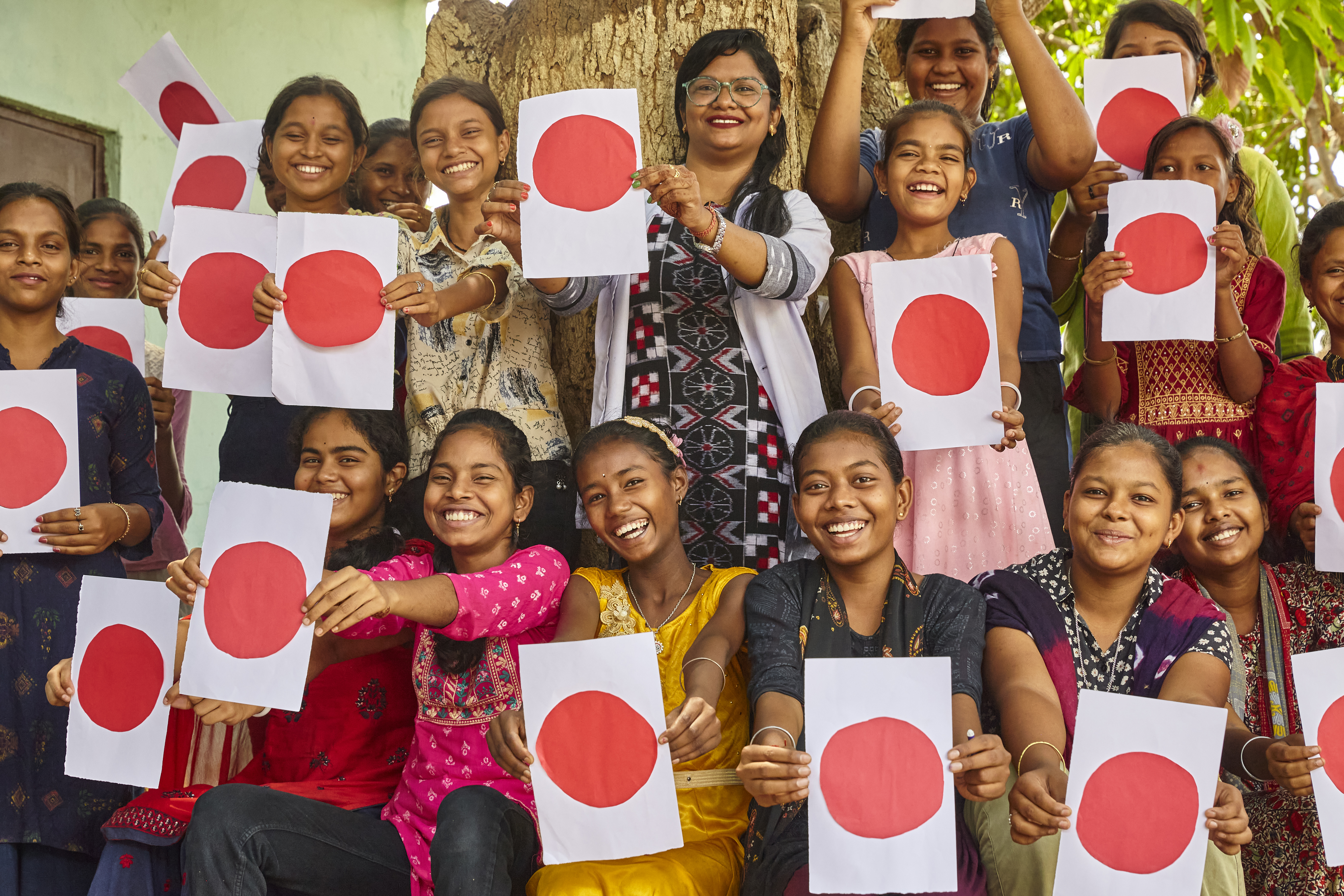 Young girls holding red dot cards — Menstrual Health Awareness